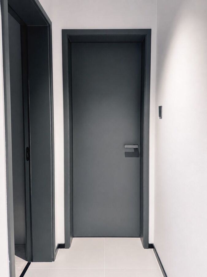 A dark grey door in a corridor