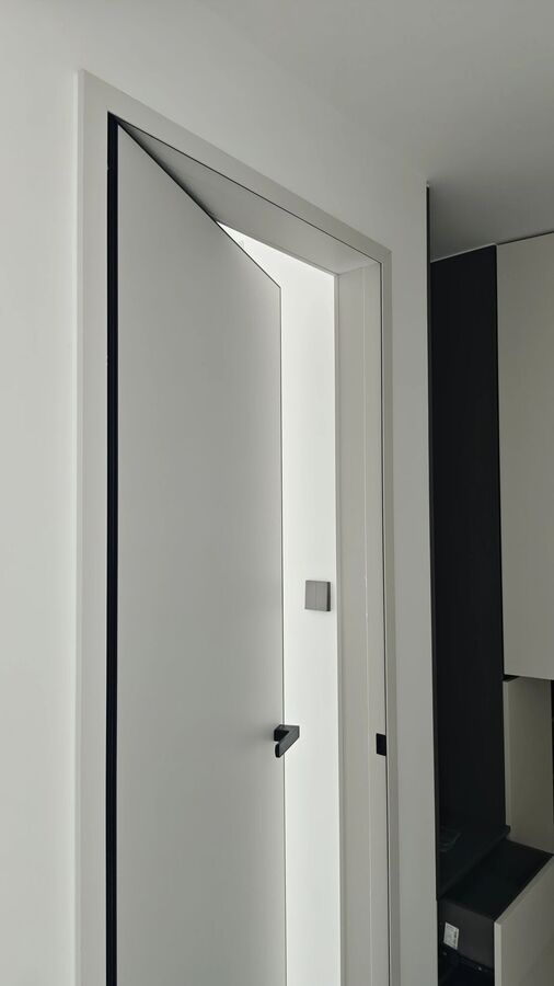 A white door half open in a quiet bedroom