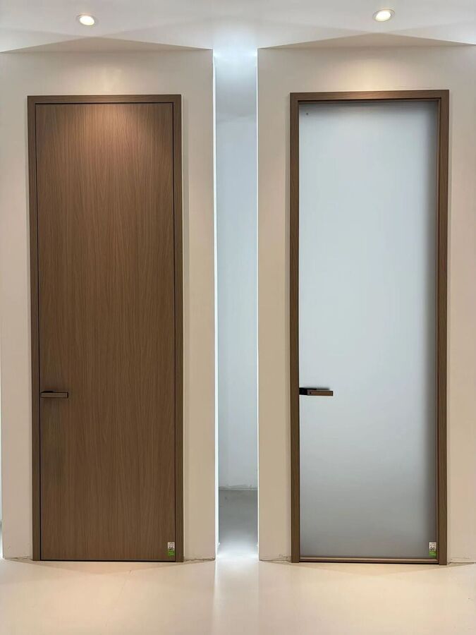 A wood grain door beside a frosted glass door in the same frame colour