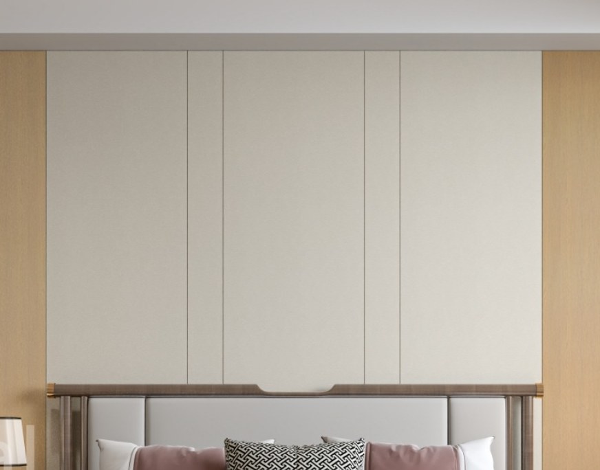 A bedroom wall in pale panels with a shaped section framing the headboard